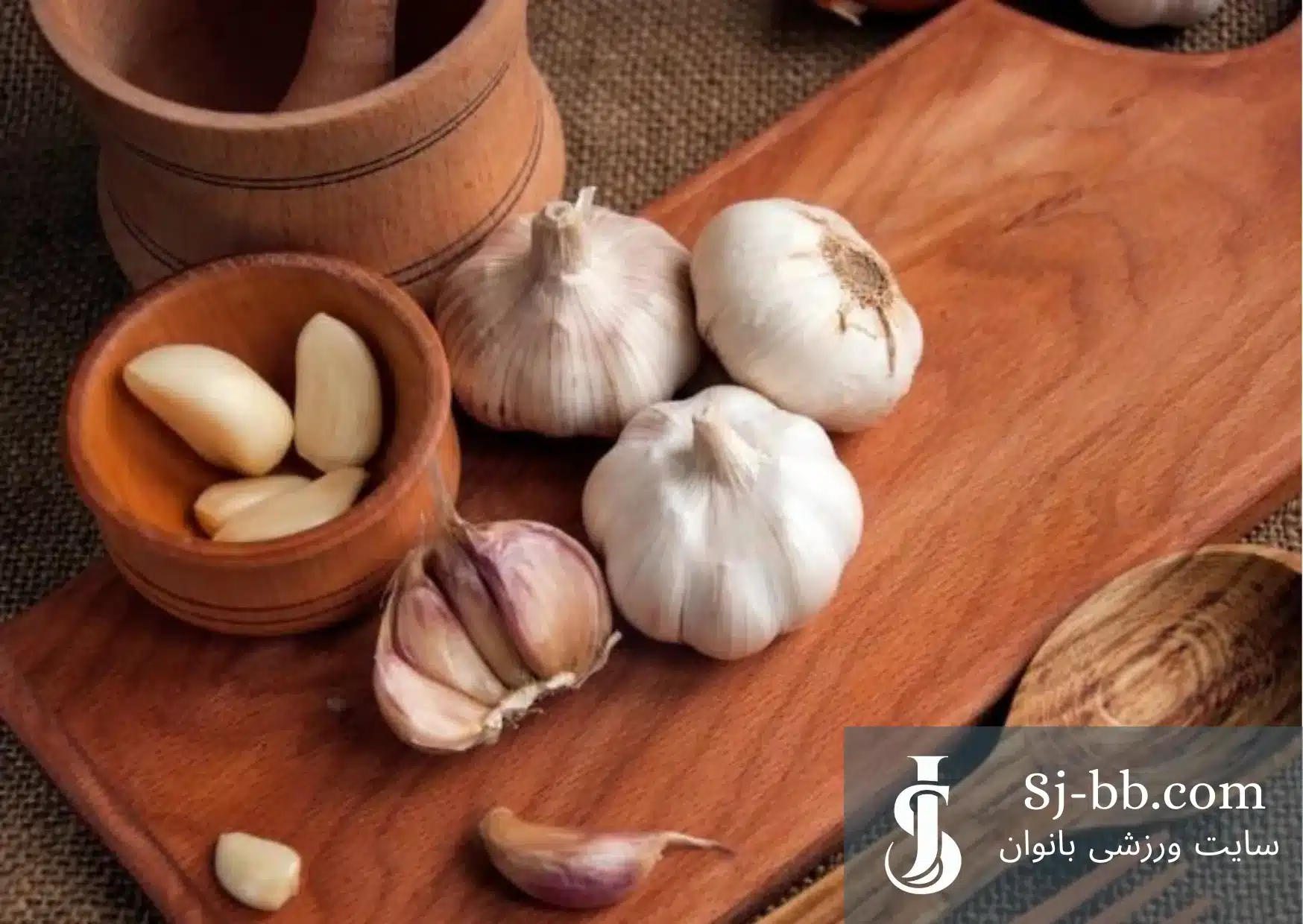 حبه‌های سیر تازه روی میز چوبی – فواید سیر برای سلامتی